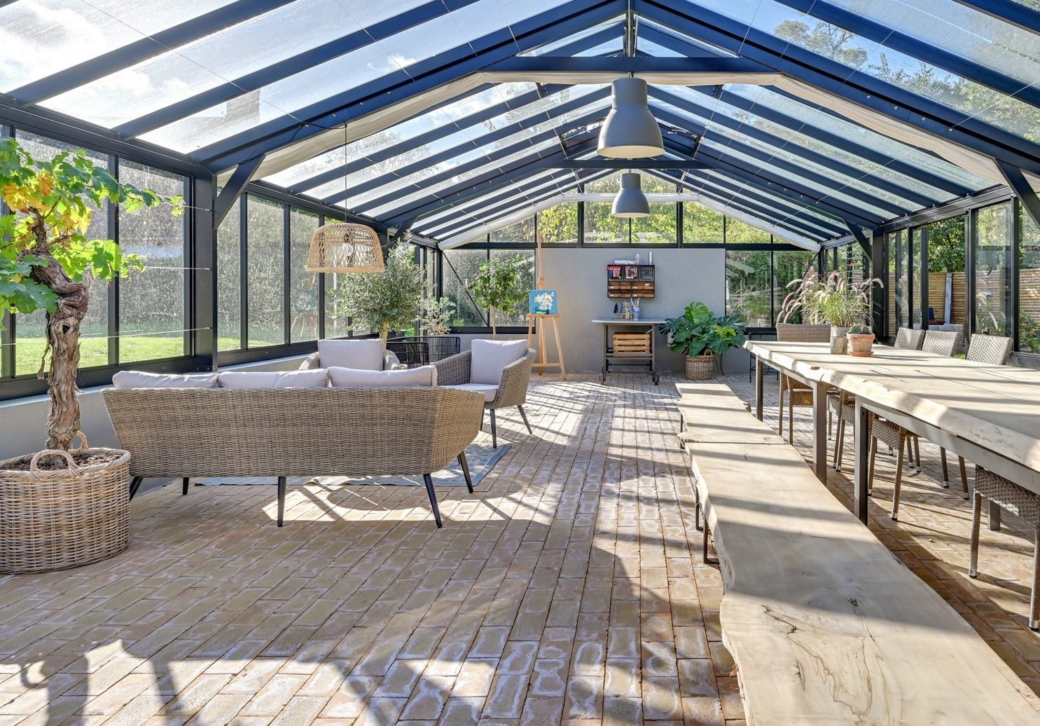 Inside a Nordic garden room, glazed wall looking onto a planted garden