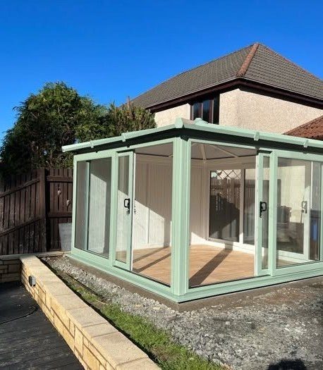 Sage green garden room with glazed doors